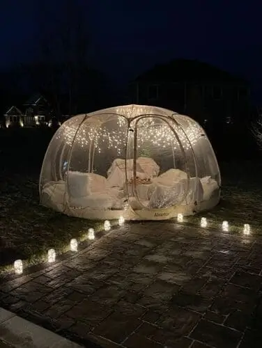 Couple enjoying a Halloween date night in a cozy bubble dome, perfect for a unique and intimate outdoor experience under the stars with a spooky seasonal vibe.