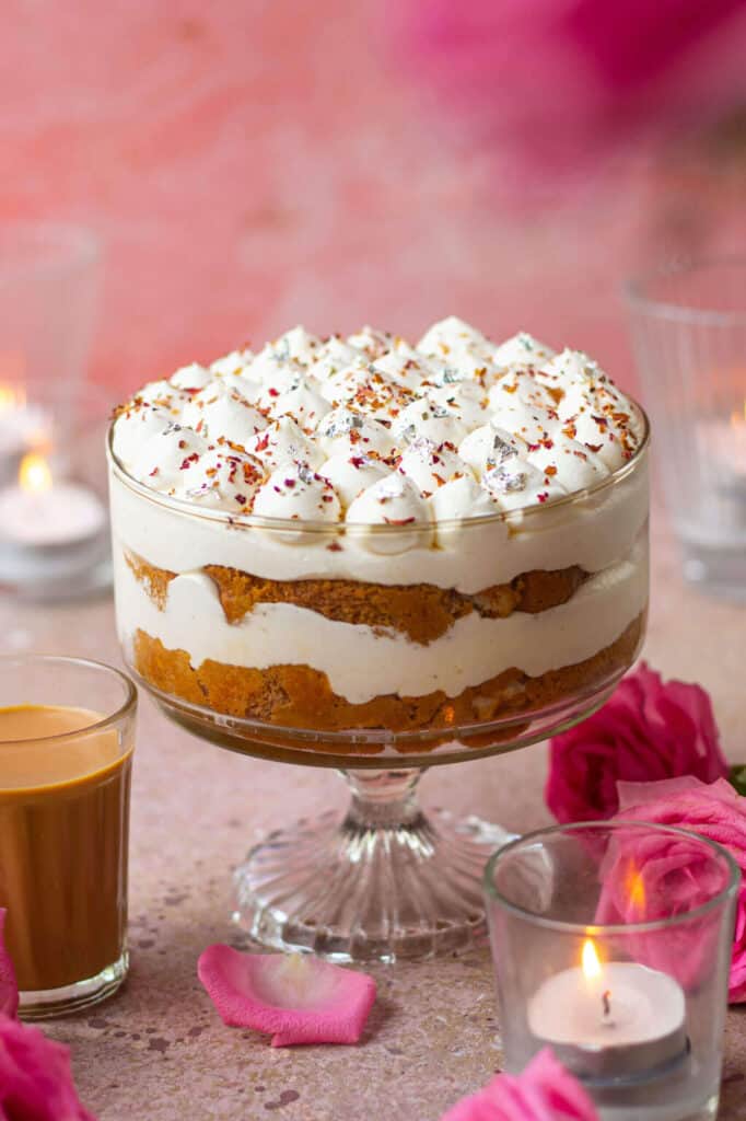 A large trifle dish of chai tea tiramisu displayed on a table with rose petals