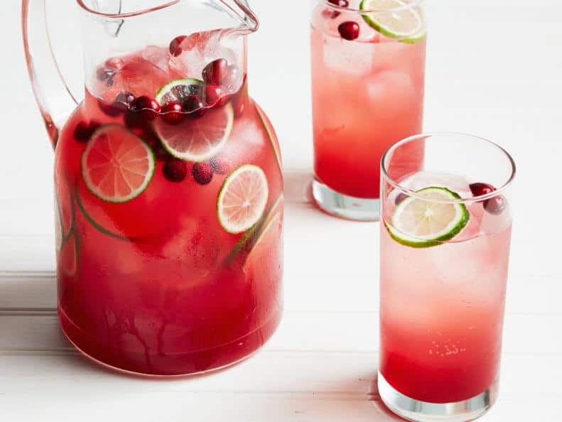 Pitcher of cranberry lime mocktail with 2 glasses