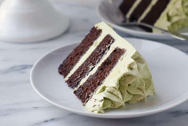 Slice of dark chocolate cake with green matcha frosting