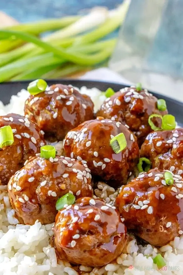 Sticky asian meatballs with green onion and sesame seeds on top