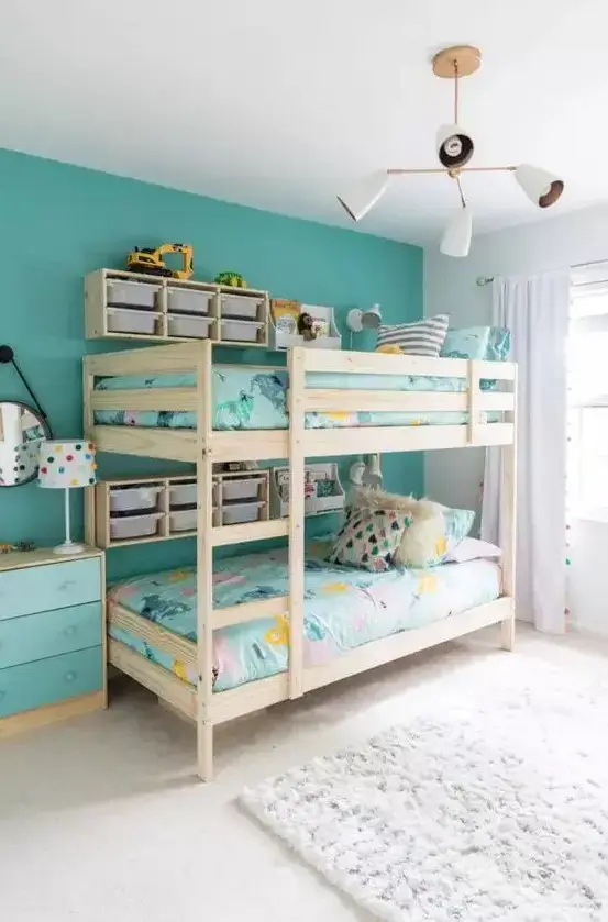 Vibrant turquoise accent wall behind bunk beds to add a cozy atmosphere to the room
