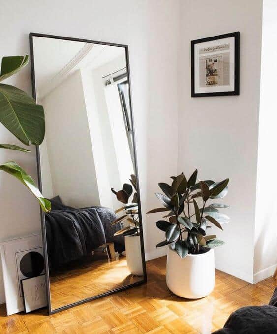 Easily style an area in your room with a large floor mirror and potted plants. Mirrors reflect light and make your space appear larger.