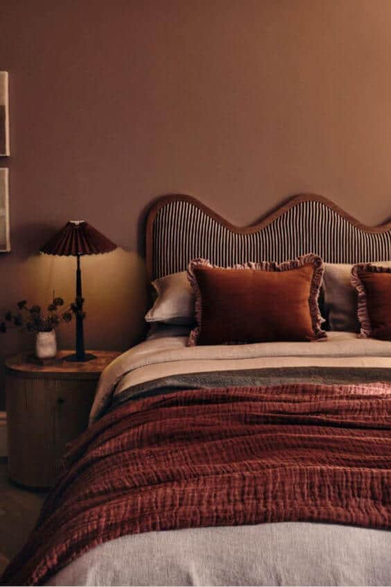 A couples' bedroom that uses terracotta and blush for a color palette.