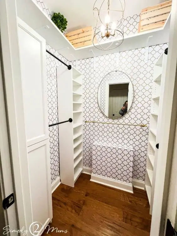 Cute small walk-in closet with chic wallpaper
