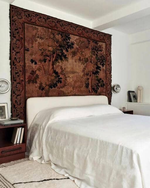 Tapestry on wall behind bed serves as a focal point and adds dimension to the space