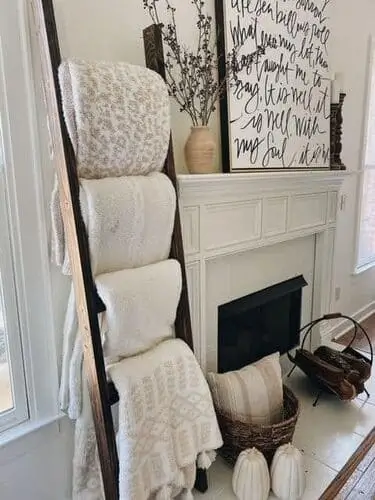 Blanket ladder in a white farmhouse living room, showcasing cozy throws and adding rustic charm. Perfect for storing and displaying blankets in a stylish and functional way, enhancing the farmhouse aesthetic.