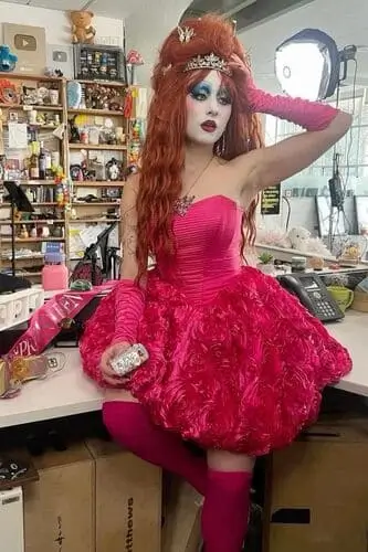 Chappell Roan Tiny Desk Concert-inspired Halloween costume featuring a pink dress, pink arm gloves, pink tights, bold hair and makeup, and a tiara, capturing the edgy and stylish look of the performance.