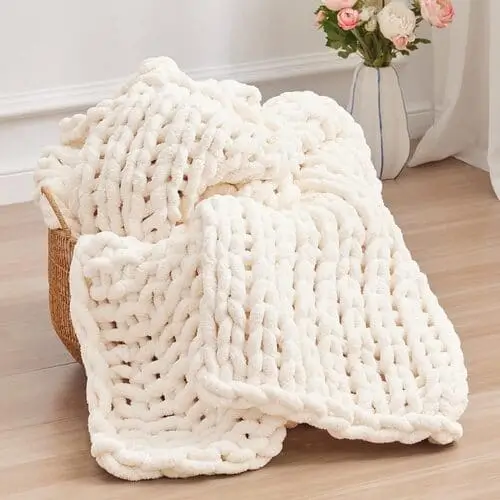 Chunky knit blanket draped over a farmhouse sofa, adding warmth, texture, and a cozy vibe to the modern farmhouse living room decor.