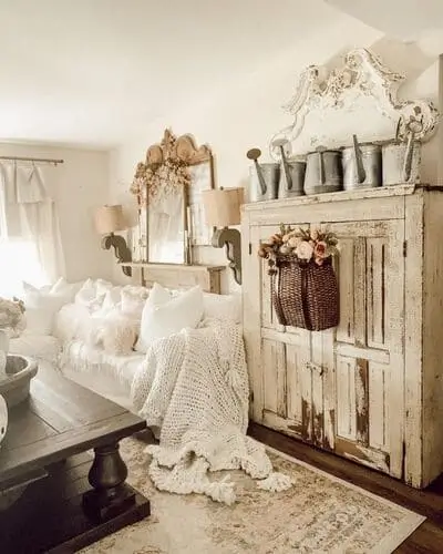 Cozy white farmhouse living room with a chunky knit blanket draped over the sofa, adding warmth and texture to the rustic, inviting space