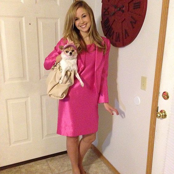 Elle Woods Halloween costume inspired by Legally Blonde, featuring a chic pink mini dress, a matching pink handbag, blonde wig, and high-heeled pink sandals, perfect for a stylish and iconic costume look.