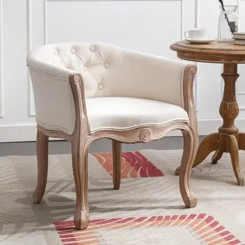 French accent chair in a living room, featuring graceful curves and a distressed wood frame, adding timeless elegance and a touch of European sophistication to the farmhouse decor.