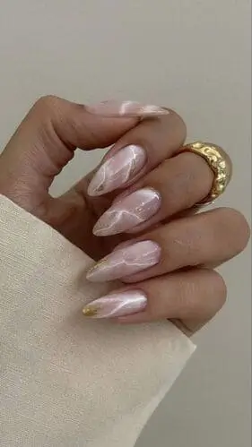 Close-up of marble nails, showcasing a chic design with natural swirls of white and gold, creating a stylish and elegant manicure.