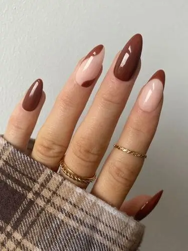 Close-up of brown fall nails with a neutral accent nail, showcasing a chic, seasonal manicure that blends rich earthy tones with a subtle, stylish twist.