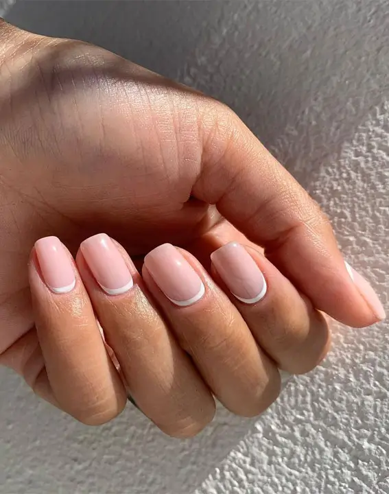 Close-up of reverse French tip fall nails with a modern twist, featuring rich autumn colors like burgundy and mustard at the cuticle, creating a bold and trendy fall manicure.