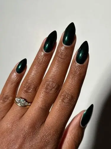 Manicure featuring rich jewel-toned nail polish, highlighting deep, vibrant colors like emerald green, sapphire blue, and amethyst purple, perfect for a luxurious fall or winter look.