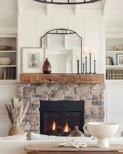 Beautiful reclaimed mantle adds charm and history in a white farmhouse living room