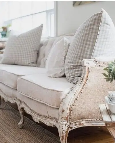 Modern farmhouse upholstered wooden sofa that combines rustic wood elements with soft, neutral fabric for a cozy and stylish living room seating option.