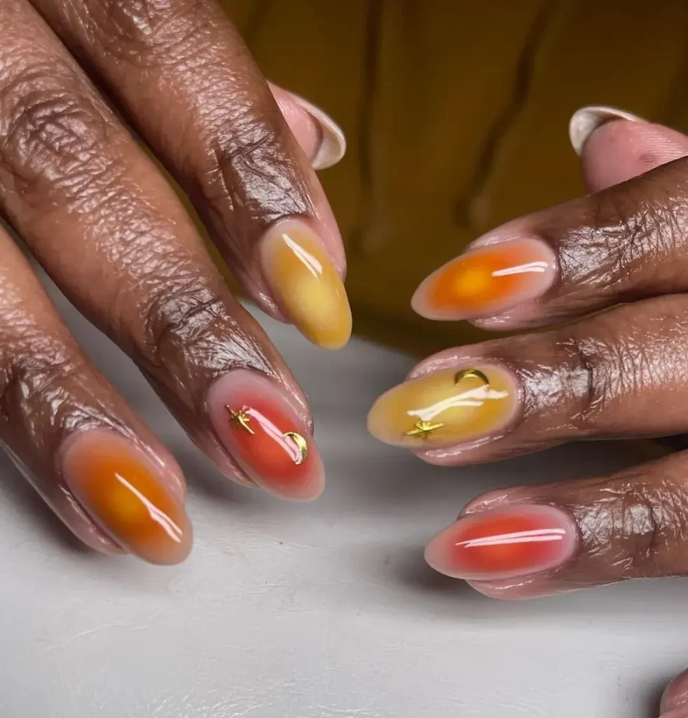 Vibrant aura nails in yellow, red, and orange hues, featuring a dynamic, gradient effect for a bold fall look.