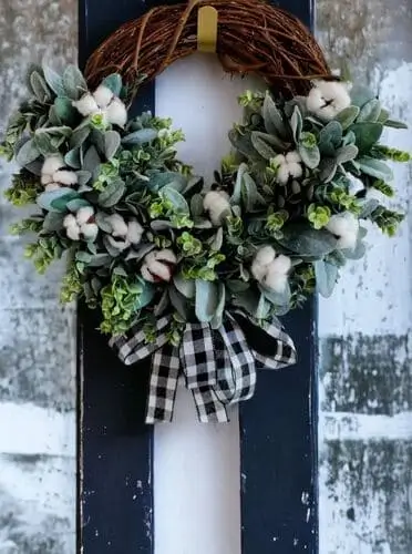 Eucalyptus, lamb's ear, and cotton wreath with a plaid bow, combining natural greenery and soft cotton with a festive plaid accent. Ideal for cozy fall or winter decor.