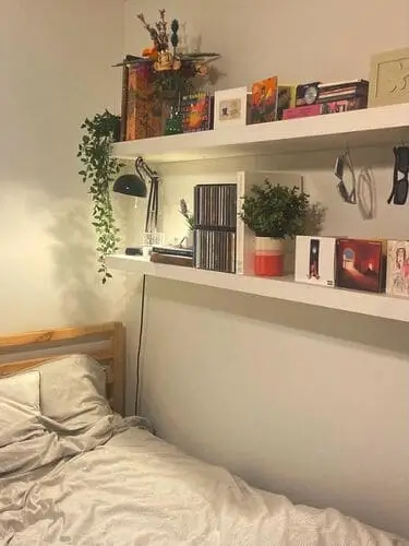 Floating shelves in a living room bedroom combo, perfect for maximizing vertical storage while maintaining a minimalist look. Ideal for small spaces to display decor, books, and essentials.