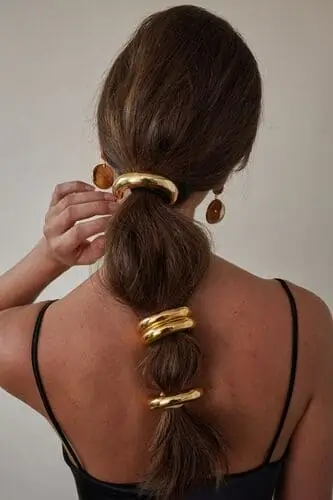 Trendy gold ponytail accessory for fall fashion, featuring a sleek and stylish design that adds a touch of elegance to your autumn hairstyles.