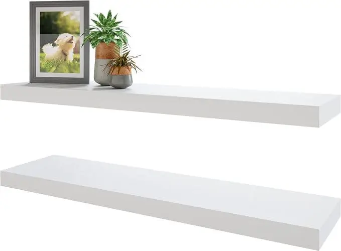 Sleek, modern white floating shelves in a living room bedroom combo, designed to seamlessly blend with minimalist decor. Great for creating storage solutions without clutter, these shelves add elegance and functionality to small apartments.