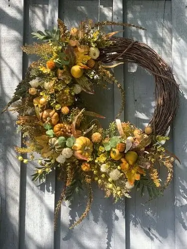 Large luxurious fall wreath featuring a blend of greens, golds, tans, yellows, oranges, and whites with pumpkins, pears, thistles, eucalyptus, amaranth tails, and berry clusters. Perfect for elegant autumn decor.