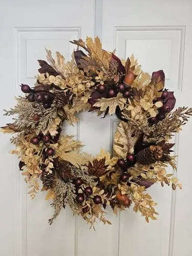 Acorn and pinecone wreath with natural elements, including autumn leaves and greenery, creating a rustic, woodland-inspired fall decor for your front door or home.