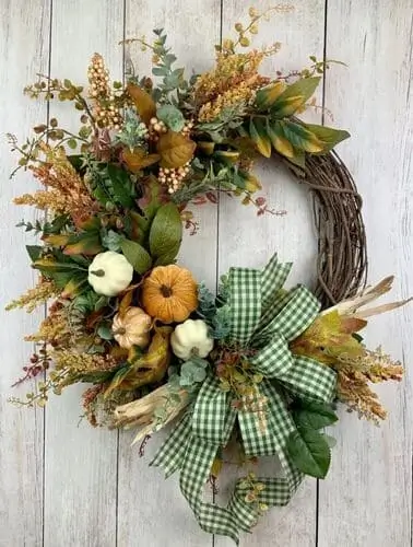 Green plaid ribbon wreath with festive bows and lush greenery, perfect for adding a cozy, rustic touch to fall or holiday home decor.