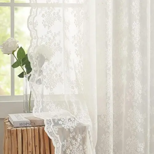 Romantic lace curtains layered in a living room bedroom combo to elegantly differentiate spaces, creating a soft, airy boundary while enhancing privacy and style.