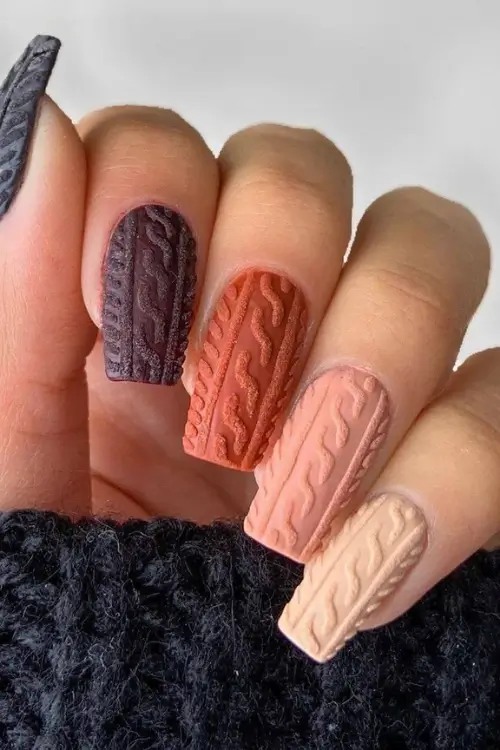 Cozy sweater nails for fall, showcasing intricate raised patterns that mimic the texture of your favorite knitwear in warm autumnal colors. Perfect for a stylish and seasonal touch.