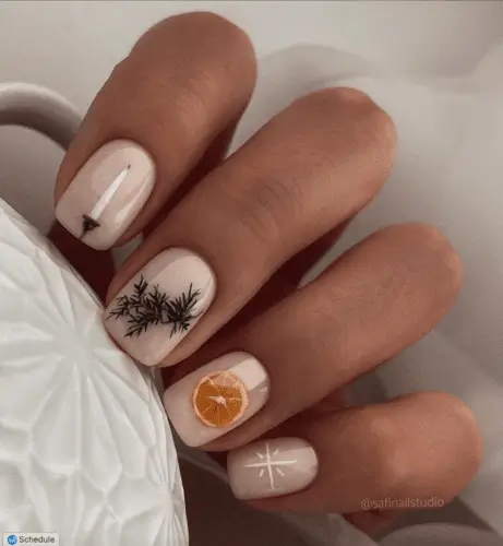 Winter solstice nails featuring festive designs: a candlestick on one nail, a pine branch on another, an orange slice on the third, and a star on the pinkie. Perfect for holiday nail art inspiration with cozy, seasonal details.