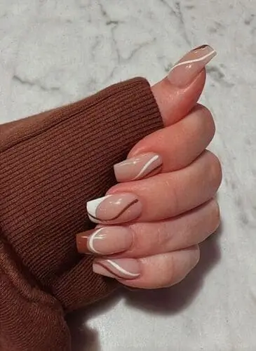 Modern abstract brown and white swirl nails—trendy nail art idea for a stylish and unique manicure look.