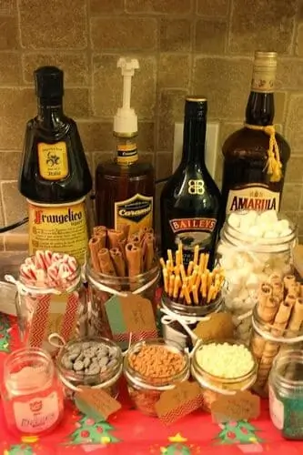 Boozy hot cocoa bar with festive mugs, alcohol options like Baileys and Kahlua, toppings, and holiday decor – perfect for adult holiday parties and cozy winter nights.