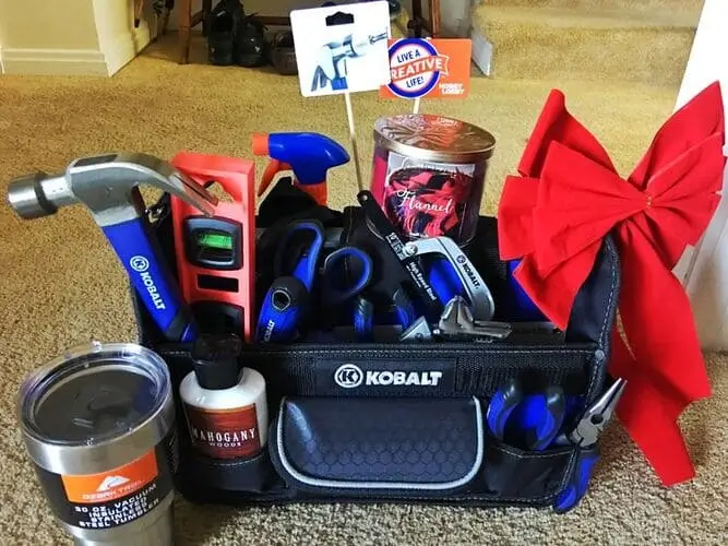 DIY tool Christmas basket for men with items like hammer, pliers, tool set, duct tape, multi-tools, wood polish, and screwdrivers.