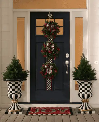 Christmas decor with black and white checkered bows on wreaths and matching checkered urns, adding a classic black and white checkered touch to holiday decorations.