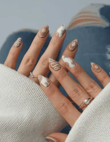 Charming brown and white gingerbread cookie-inspired nails with delicate icing details—perfect holiday nail art look to get festive and cozy.