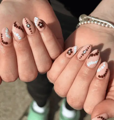 Tropical brown and white Hawaiian-themed nails featuring floral motifs and tie-dye inspired patterns, combining island vibes with a chic, earthy color palette.