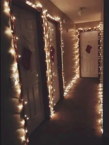 Christmas door decoration ideas: Festive white Christmas lights and red stockings hung on door for a cozy holiday look.