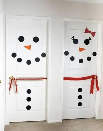 Christmas door decoration ideas for kids' rooms: Adorable snowman and snowwoman faces on bedroom doors, perfect for boys and girls this holiday season.