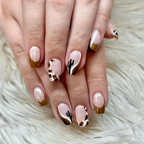 Trendy cow print Western nails with cactus accent—unique nail art inspiration for a playful, Southwestern-inspired manicure.