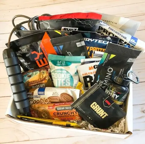 Christmas gift basket for men who love the gym. Include a jump rope for cardio, yummy protein treats, protein powders, gym towel, a new water bottle, and more.