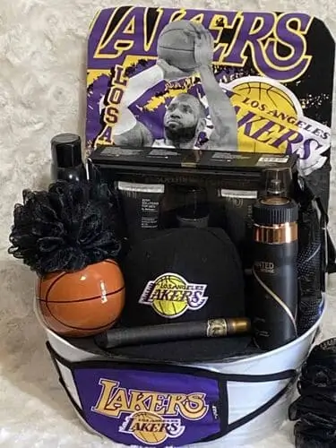 Sports fan Christmas gift basket filled with team merchandise like jerseys and hats, game-day snacks, collectible items, and drinkware for holiday gifting.