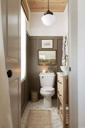 Narrow bathroom with Gloucester Sage wainscoting by Benjamin Moore, light wood vanity, and pendant light.