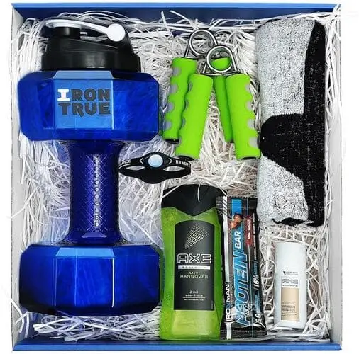 Fitness gym Christmas gift basket for men with protein powder, shaker up, deodorant, protein bar, arm strengtheners, and personal gym towel