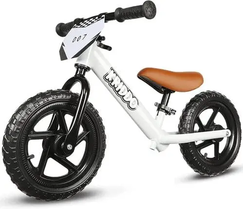 White balance bike with a tan leather seat and lightweight frame, available on Amazon; an ideal Christmas gift for 4-year-olds to develop balance and coordination.