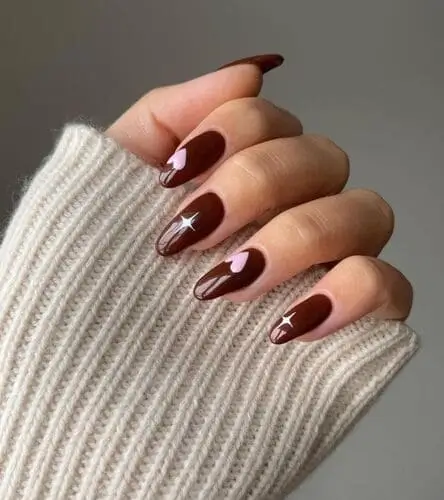 Brown Valentine's Day nails with pink accent nails and white sparkle star accents for a trendy, romantic, and festive manicure perfect for the season of love.