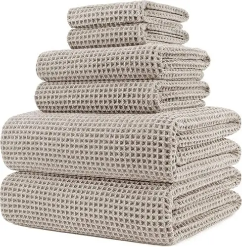 Set of chic modern bathroom hand towels in neutral tones, adding style to apartment decor.