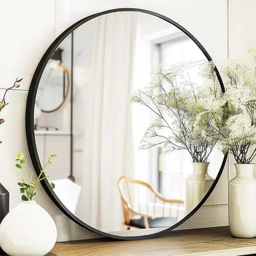 Chic round entryway mirror styled with decorative accents, perfect for enhancing cute apartment decor ideas while adding depth and light to your space.